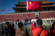 Des touristes devant la Cité Interdite, place Tiananmen, le 1er mars 2017 à Pékin