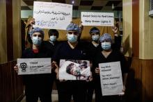 Des membres du personnel médical d'un hôpital tiennent des affiches condamnant l'attaque chimique pr