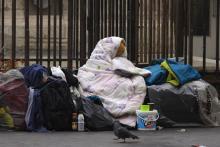 Une femme sans-abris est enveloppée dans une couverture sur le trottoir d'une rue parisienne, le 3 d