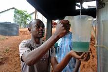 Un homme récupère dans un récipient en plastique de l'huile essentielle de géranium, le 28 avril 201