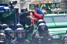 Des policiers tentent de faire descendre une manifestante anti-G20 grimpée sur un véhicule blindé de