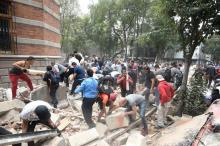 Des mexicains déblaient les débris d'un bâtiment endommagé par un tremblement de terre à Mexico, le 