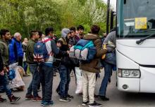 Des migrants montent dans un bus à Grande-Synthe (Nord), le 14 avril 2017 après qu'un incendie a rav