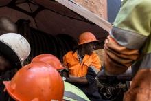 Des techniciens se lavent les mains après avoir posé des câbles électriques dans un tunnel sous Joha