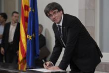 Le président séparatiste catalan Carles Puigdemont, au Parlement régional à Barcelone, signe une déc