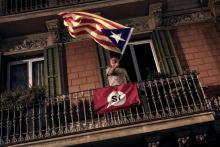 Un homme agite un drapeau pro-indépendance de la Catalogne le 1er octobre 2017 à Barcelone
