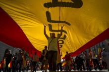 Des manifestants tiennent un drapeau espagnol géant lors d'un rassemblement contre l'indépendance de