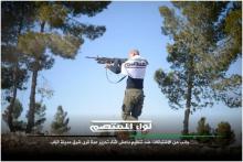 Enveloppé dans le drapeau de la brigade, un combattant de Liwa al-Mutasim ouvre le feu avec une mitrailleuse américaine M249.