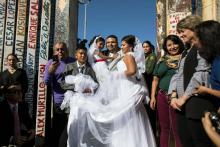 Bride Evelia Reyes and groom Brian Houston pose for pictures after marrying at an open gate on the U