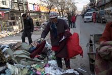 Une femme récupère des vêtements abandonnés dans des immeubles détruits à Pékin, le 27 novembre 2017