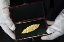 Photographie prise le 15 novembre 2017 à Paris d'une feuille de laurier en or destinée à la couronne