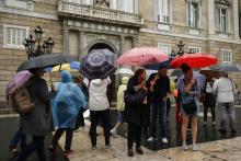 Des touristes devant le palais de la Generalitat, le siège du gouvernement catalan, à Barcelone, le 