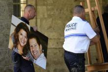 Un policier retire le portrait du policier Jean-Baptiste Salvaing et de sa compagne Jessica Schneide