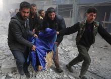 Des Syriens transportent une victime après une frappe aérienne dans la ville rebelle de Hamouria, da