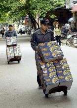 Des employés chargent des boîtes de bière pour les livrer à Hanoi, le 18 mai 2004
