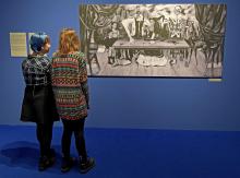 Des visiteurs d'une exposition en Pologne consacrée à Frida Kahlo contemplent une photo d'une toile 