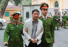 L'ancien dirigeant d'une compagnie pétrolière publique et ex-cadre du parti communiste vietnamien Trinh Xuan Thanh est conduit par des policiers vers le tribunal de Hanoi qui l'a condamné lundi 22 jan