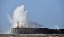 De fortes vagues viennent se fracasser sur le phare de Newhaven, sur la côte sud du Royaume-Uni pend