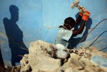 Des Haïtiens continuent de déblayer les ruines du tremblement de terre un an après, dans une rue de Port-au-Prince le 8 janvier 2011