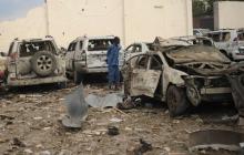 Un Somalien au milieu de carcasses de voitures laissées par un attentat à la voiture piégée visant l'hôtel Doorbin de Mogadiscio, le 24 février 2018