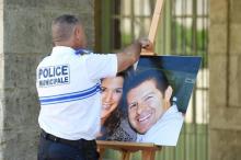 Un officier de police tient le 20 juin 2016 à Pézénas dans l'Hérault une photographie de Jessica Schneider et Jean-Baptiste Salvaing, victimes d'un assassinat jihadiste à Magnanville, le 13 juin 2016