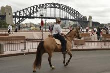 Glenn Morris, un agriculteur australien, va manifester à cheval à Sydney pour réclamer au gouvernement l'abandon de projets miniers en faveur des énergies renouvelables, le 24 mars 2018
