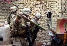 Des Marines cassent un mur d'une maison abandonnée à Ramadi en novembre 2006