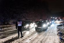 Un policier devant des véhicules bloqués par la neige sur la D444 près de Bièvres, dans l'Essonne, le 7 février 2018