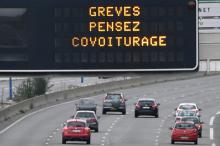 Des voitures passent sous un panneau lumineux portant l'inscription "grèves: pensez covoiturage", sur une autoroute à Toulouse, le 2 avril 2018