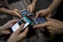 Les patients d'un groupe de désintoxication numérique montrent leurs téléphones portables, à Rio, le