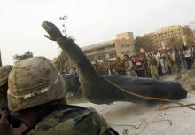 La statue du dictateur irakien Saddam Hussein déboulonnée le 9 avril 2003 avec l'aide d'un blindé américain à Bagdad.