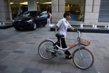 A woman wheels a Mobike rental bicycle in Beijing