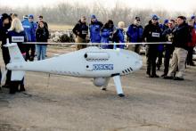 Des membres de l'OSCE s'apprêtent à tester le 28 mars 2018 à Stepanivka, le prochain vol de leur drone, censé surveiller l'application des accords de paix