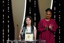 L'actrice kazakhe Samal Esljamova (G) reçoit décroché le prix d'interprétation féminine au Festival de Cannes pour son rôle dans "Ayka" de Sergueï Dvortsevoï, le 19 mai 2018
