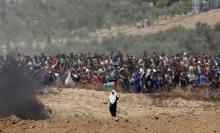 Des Palestiniens manifestent près de la frontière israélienne à Gaza, le 14 mai 2018