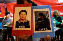 Des photos de dissidents emprisonnés en Chine, le Taïwanais Lee Ming-che et le défenseur de la langue tibétaine Tashi Wangchuk, brandies à Taipei le 4 juin 2017 lors d'une manifestation au 28e anniver