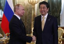 Le président russe Vladimir Poutine (g) accueille au Kremlin à Moscou le Premier ministre japonais Shinzo Abe, le 26 mai 2018