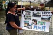 La professeure Milvia Lopez montre des photos d'élèves portés disparus après l'éruption du "Volcan de feu", devant une morgue improviséee, le 8 juin 2018