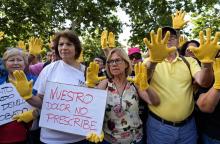 Des manifestants aux mains gantées de jaune devant le tribunal de Madrid où s'est ouvert le premier procès des "bébés volés" du franquisme, le 26 juin 2018
