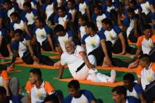 Le Premier ministre indien Narendra Modi (c) participe à une séance de yoga en plein air à l'occasion de la Journée internationale du yoga, le 21 juin 2018 à New Delhi