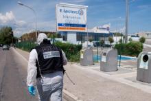 Un membre de la police technique et scientifique relève des indices devant le magasin Leclerc de la Seyne-sur-Mer après une attaque au cuttter, le 17 juin 2018 dans le Var