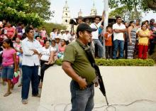 Un garde armé surveille un meeting de campagne du candidat au Sénat Nestora Salgado du parti Morena, le 20 mai 2018 à San Luis Acatlan, dans l'Etat de Guerrero, au Mexique