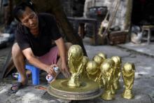 Dernier coup de spray pour des répliques du trophée de la coupe du monde fabriquées au Vietnam par l'artisan Vuong Hong Nhat, le 5 juin 2018