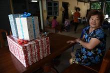 Une parente de Pheeraphat, l'un des jeunes membres d'une équipe de football bloquée dans la grotte de Tham Luang en Thaïlande, montre les cadeaux préparés pour fêter son anniversaire dès qu'il sera év
