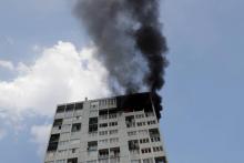 De la fumée noire s'échappe de l'immeuble touché par un incendie à Aubervilliers au nord-est de Paris le 26 juillet 2018