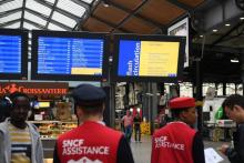 Des employés de la SNCF assistent les voyageurs le 13 juin 2018 à la gare de Saint-Lazare où le trafic est totalement interrompu