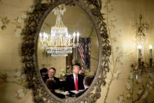 US President Donald Trump (R) and US Secretary of State Mike Pompeo (L) are reflected in a mirror as they attend at a breakfast meeting with the NATO Secretary General and staff at the US chief of mis