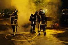 Des pompiers luttant contre l'incendie d'une voiture, à Nantes, dans l'ouest de la France, le 4 juillet 2018