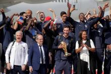 Le capitaine de l'équipe de France Hugo Lloris brandit la Coupe du monde entourée de ses coéquipiers, le 15 juillet 2018 à Moscou