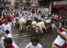 Des participants à l'encierro de la San Fermin courent avec les taureaux, le 7 juillet 2018 à Pampelune, en Espagne